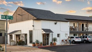 A two-story building with a flat roof, a covered entrance, and a balcony on the upper floor.