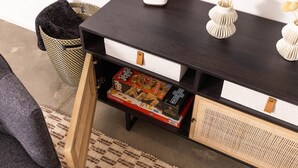 Ein dunkles Holzkonsolentisch mit offenen Schubladen, einem gewebten Korb und dekorativen Vasen.