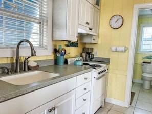 Una cocina con pileta, estufa y alacenas.
