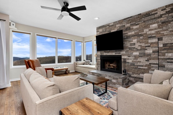 Large living room with plenty of seating, 65" Roku HDTV, and cozy fireplace.