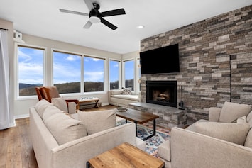 Large living room with plenty of seating, 65" Roku HDTV, and cozy fireplace.
