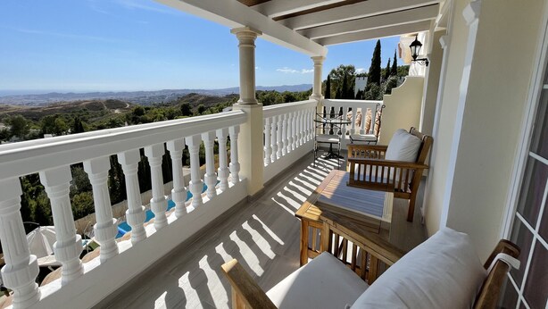 A balcony with a view of the landscape, white balustrades, and outdoor furniture. - Malagasuite Villa Moriana (Mijas Pueblo)