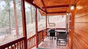 A wooden deck with a grill area, a table, and chairs. - Secluded Escape | Spacious Deck (Ruidoso)