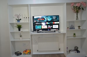 Relax and unwind in this stylish living room, featuring a flat-screen TV and comfortable seating area.