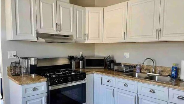 A modern kitchen with white cabinets, stainless steel appliances, and granite countertops. - Modern, Comfortable 3bd w/ Backyard Space & Grill (Torrance)