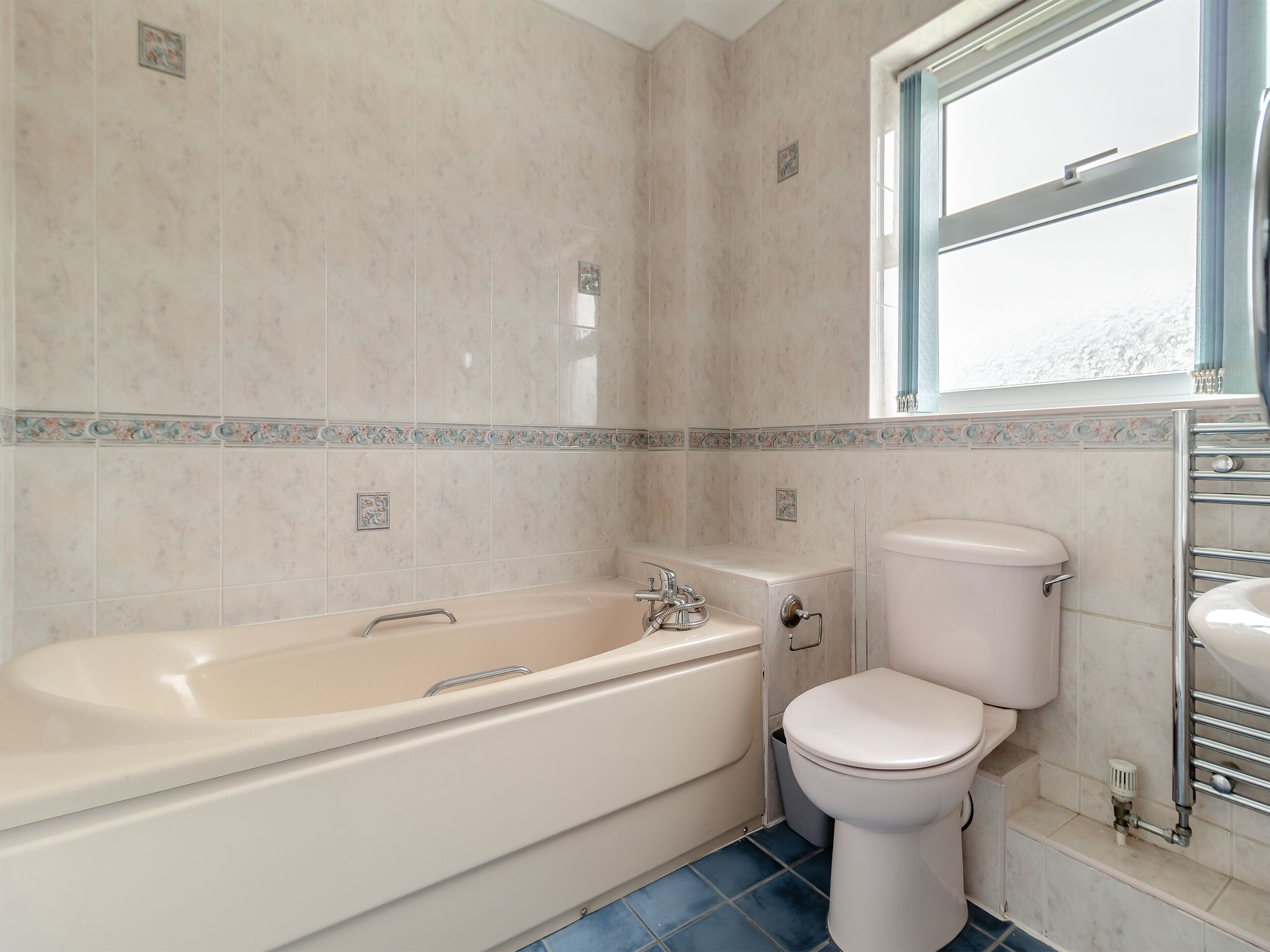 Un baño con bañera, inodoro y ventana.