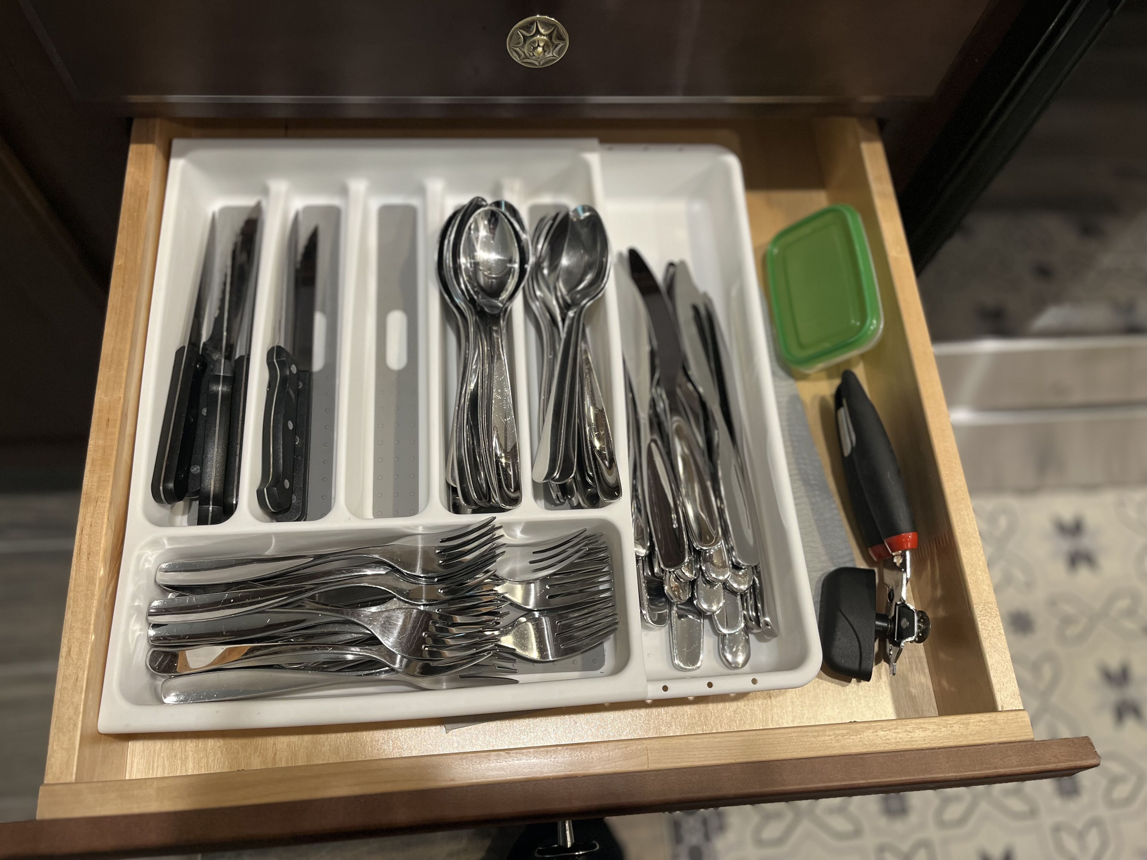 A drawer containing various utensils including forks, knives, and spoons, neatly organized in compartments.