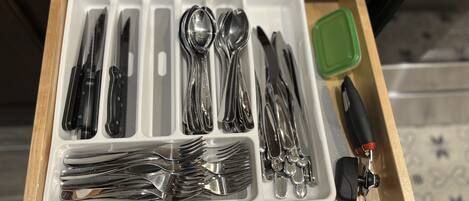 A drawer containing various utensils including forks, knives, and spoons, neatly organized in compartments.