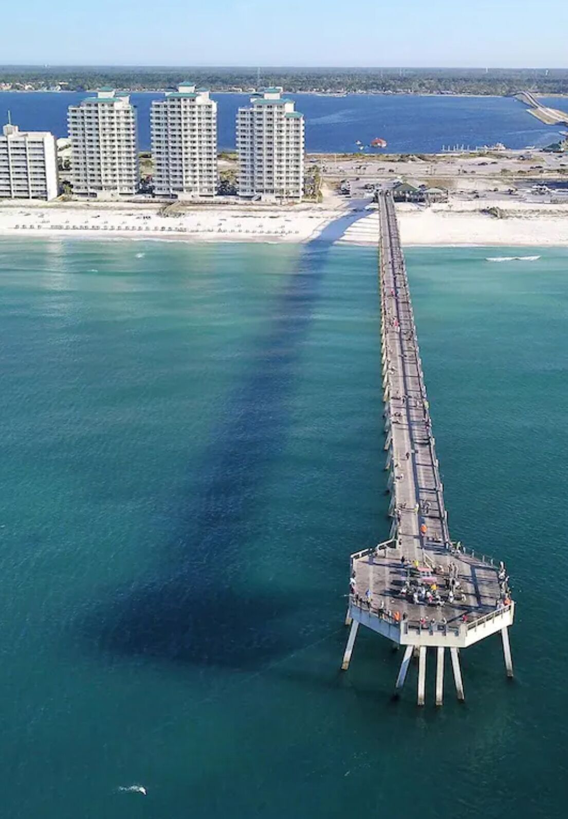 Eine Luftaufnahme eines Piers, der sich über das Wasser erstreckt, mit Gebäuden im Hintergrund.