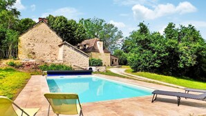 A stone building with a swimming pool, two chairs, and a bench. - La Metairie De La Garenne (Nadaillac De Rouge)