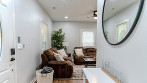 A modern living room with two brown sofas, a white coffee table, and a white bench. - Woodruff's Southern Nest, located few blocks from historic downtown Woodruff! (Woodruff)