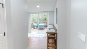 A hallway leading to a patio with a wooden table and chairs. - Woodruff's Southern Nest, located few blocks from historic downtown Woodruff! (Woodruff)