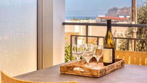 A balcony with a table, a wine bottle, and glasses on a tray.