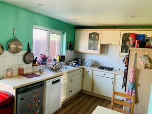 Kitchen with a dishwasher, stove, and sink, featuring a window for natural light.