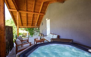 A spa area with a hot tub, wooden furniture, and a covered patio. - Lovely home in Sisinec with outdoor swimming pool (Sisinec)