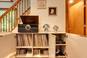 A wooden staircase with a vintage radio and vinyl records on shelves.