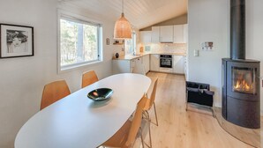 A modern kitchen with white cabinets, a built-in oven, and a wood-burning stove. - 2 bedroom cozy home in Jørpeland (Jørpeland)