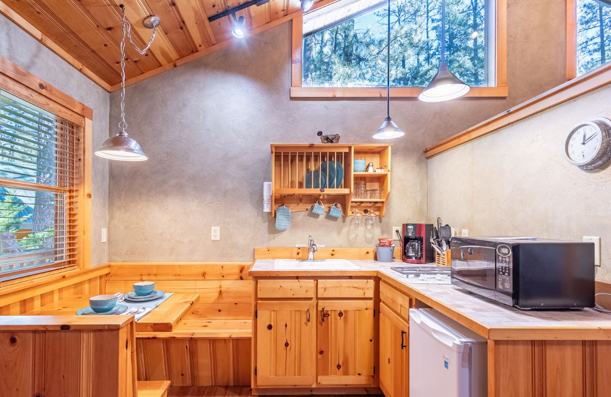A kitchen and dining area with wooden cabinets, a microwave, and a sink.