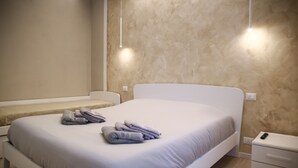 Une chambre à coucher avec un grand lit, une table de chevet et une commode.