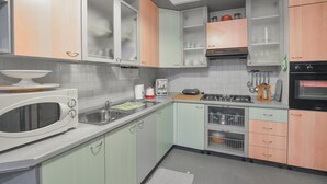 Une cuisine équipée d’un four à micro-ondes, d’un grille-pain, d’un évier, d’une cuisinière et d’un four.