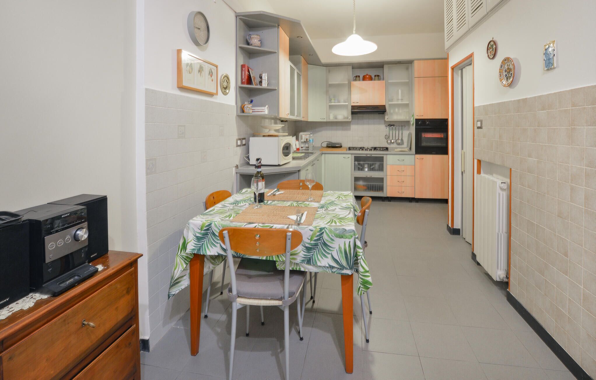 Une cuisine de taille réduite comprenant une table à manger, des chaises et un four à micro-ondes.