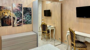 Un baño moderno con tocador, espejo, una silla de estampado de leopardo y obras de arte en la pared.