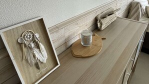A room with a wooden table, a framed dreamcatcher, a candle, and a wooden sculpture.