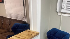 Ein modernes Zimmer mit einer Holztresore und einem blauen, gepolsterten Sessel mit Metallfüßen.