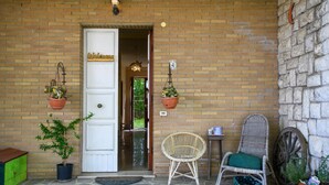 A brick building with a white door marked "Welcome".