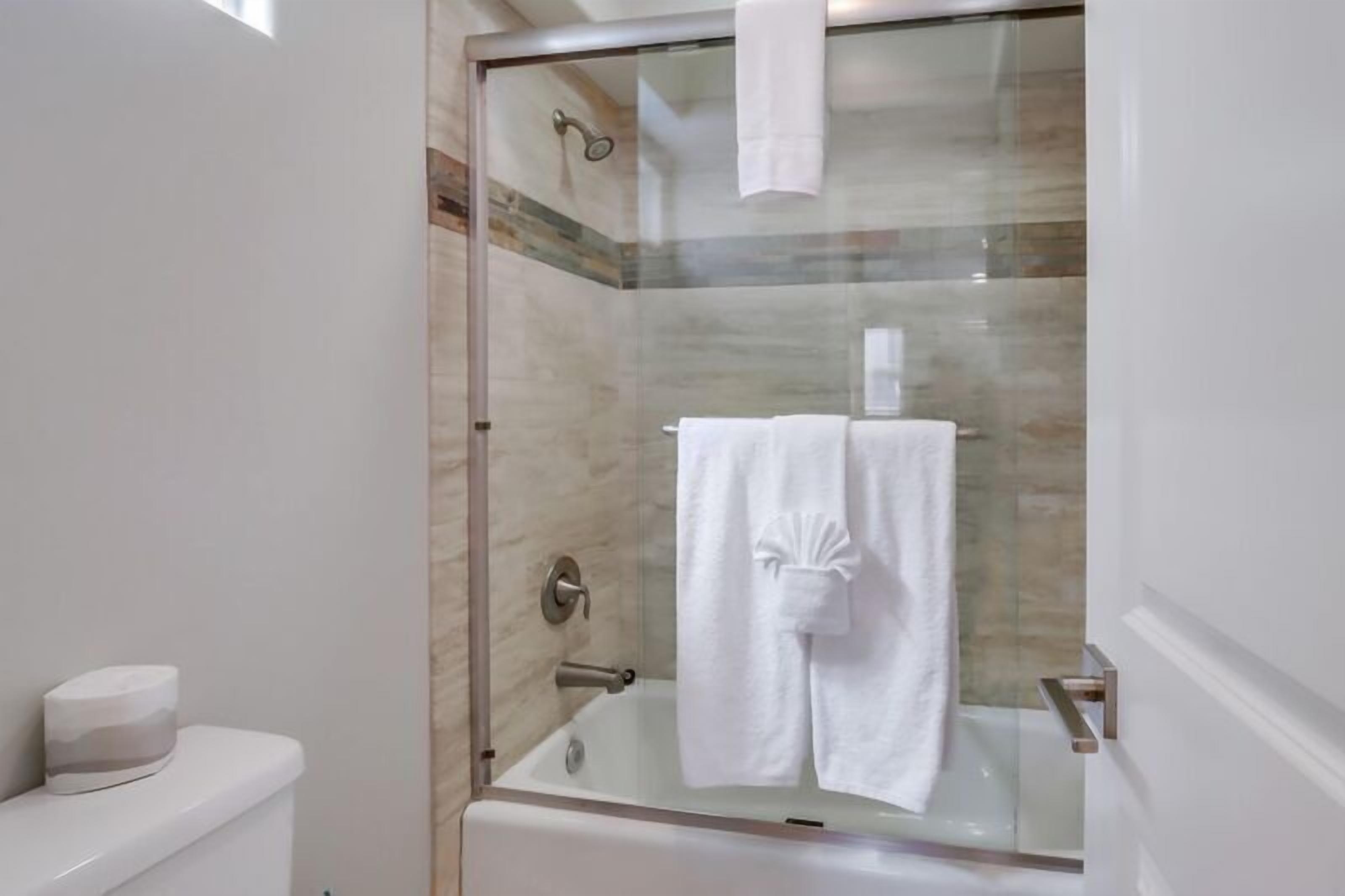 A glass-enclosed shower stall with a white towel hanging on the door.