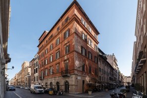 A historic building with a corner facade, multiple windows, and a ground-level entrance.