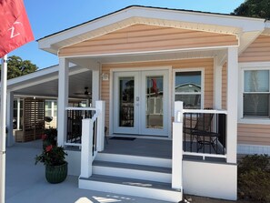 A house with a porch, a front door, and a small staircase leading to the entrance.