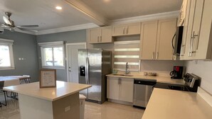 Una cocina moderna con electrodomésticos de acero inoxidable, una isla central y armarios de tonos claros.