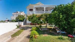 A two-story house with a balcony, surrounded by greenery and a paved driveway. - Awesome apartment in Bibinje with WiFi (Bibinje)