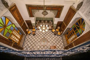 Um quarto com chão estampado, mobiliário de madeira e um candelabro.
