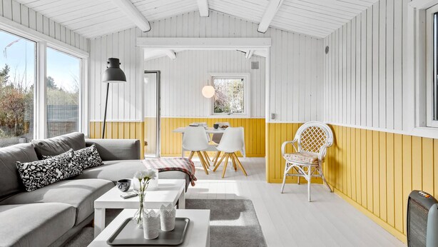 Un salon moderne comprenant un canapé, une table basse et un coin repas avec une table et des chaises.