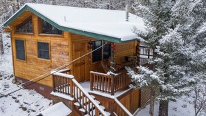 A wooden cabin with a covered deck and a staircase leading to a second level. - Romantic Cabin | River Sounds | Hiking (Ruidoso)