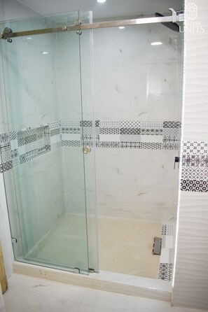 A glass-enclosed shower with a tiled floor and a door with a handle. - Modern Ocean View Condo - Marina Puerto Vallarta (Puerto Vallarta)