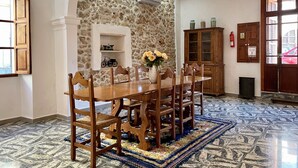 Un espace repas agrémenté d’un mur en pierre, de meubles en bois et d’un tapis à motifs.