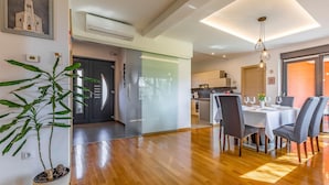 Uma cozinha moderna com área de refeições, piso de madeira e uma planta em vaso.