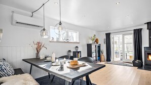 A modern kitchen with a dining table, pendant lights, and a built-in stove. - 3 bedroom stunning home in Højby (Højby)