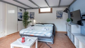 A compact bedroom with a bed, a small table with a kettle, a TV, and artwork on the walls. - GuestHost - Cozy studio apartment of about 50 sqm with mezzanine, located on the ground floor (one step at the entrance), able to comfortably accommodate up to 4 people. The accommodation is located in a quiet neighborhood, with all the main services. Wi (Pisa)