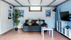 A living room with a sofa, a coffee table, a TV, and a potted plant. - GuestHost - Cozy studio apartment of about 50 sqm with mezzanine, located on the ground floor (one step at the entrance), able to comfortably accommodate up to 4 people. The accommodation is located in a quiet neighborhood, with all the main services. Wi (Pisa)