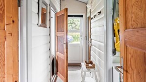 A narrow hallway with wooden doors and a window at the end. - 2 bedroom gorgeous home in Nakskov (Nakskov)