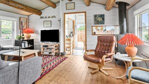 A cozy living room with a fireplace, wooden beams, a TV, and a comfortable seating area. - 2 bedroom gorgeous home in Nakskov (Nakskov)