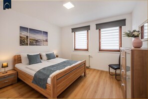 A bedroom with a wooden bed, a nightstand, a dresser, and a chair.