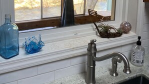 A kitchen with a window, a sink, and various items on the counter. - Cozy creekside home with deck, 15 min to airport, shopping, 1 hr to Crater Lk. 
 (Eagle Point)