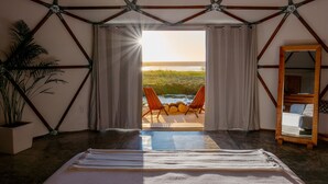 A room with a large window, a bed, a potted plant, and a wooden chair by the window. - La Poza Boutique Hotel & Spa - Adults Only (Todos Santos)