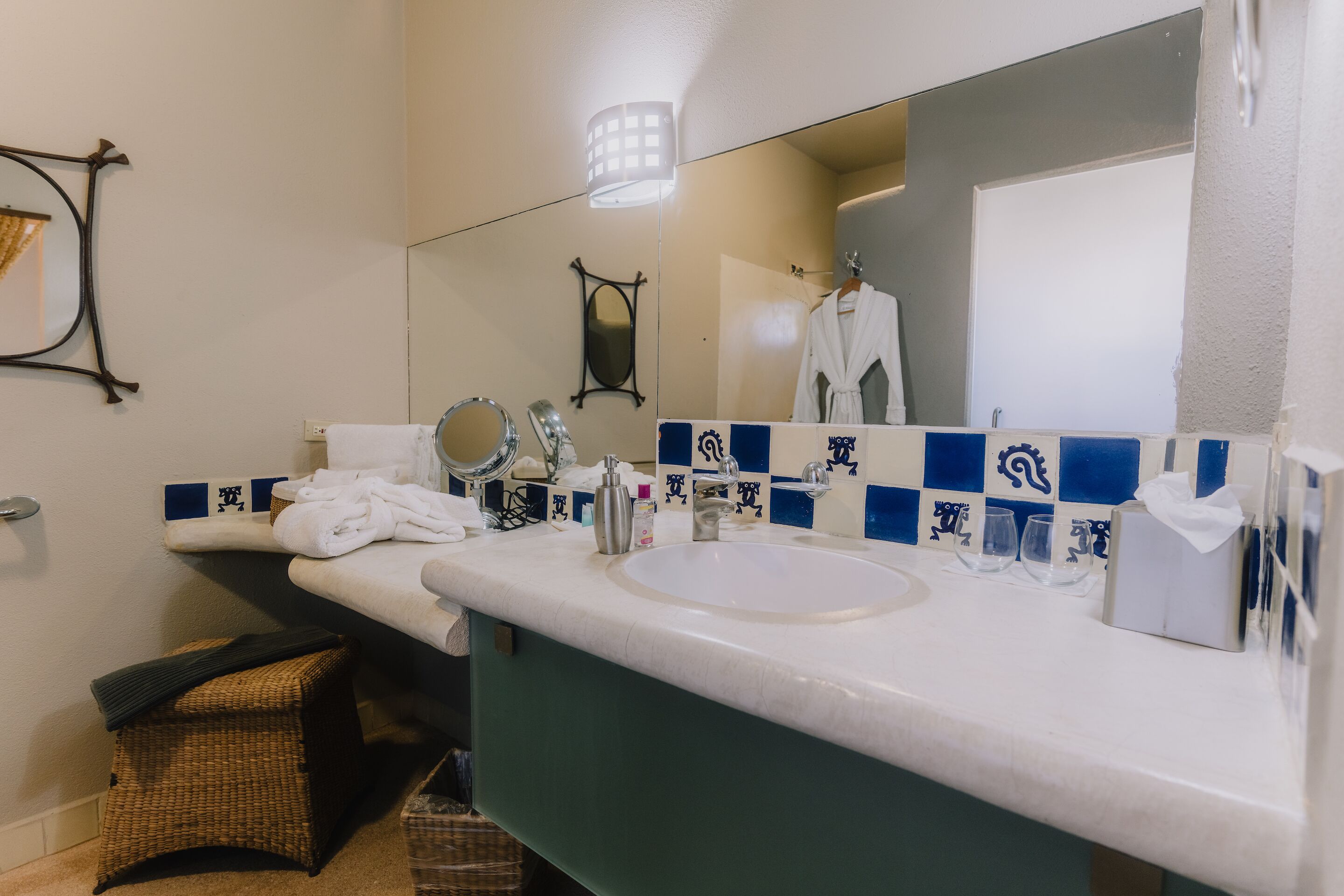 A bathroom with a white sink, a mirror, and a towel rack.