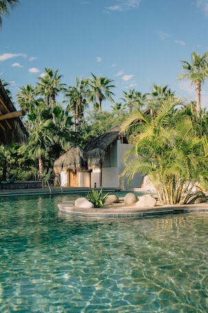 Una piscina al aire libre, camas de piscina gratis, sombrillas